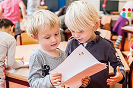 Twee kinderen in de klas met papier in hun hand